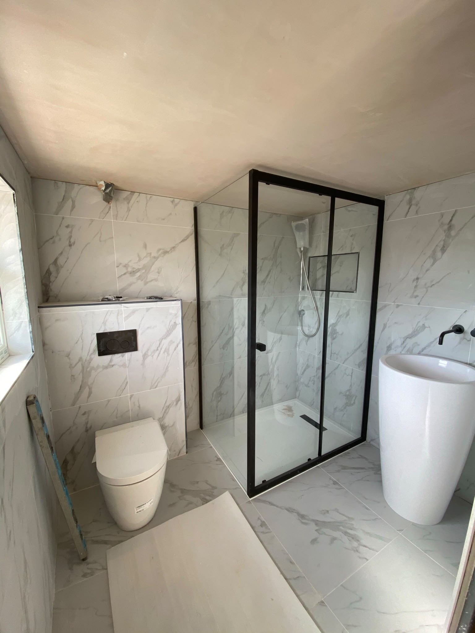 Completed marble-effect bathroom in Streatham