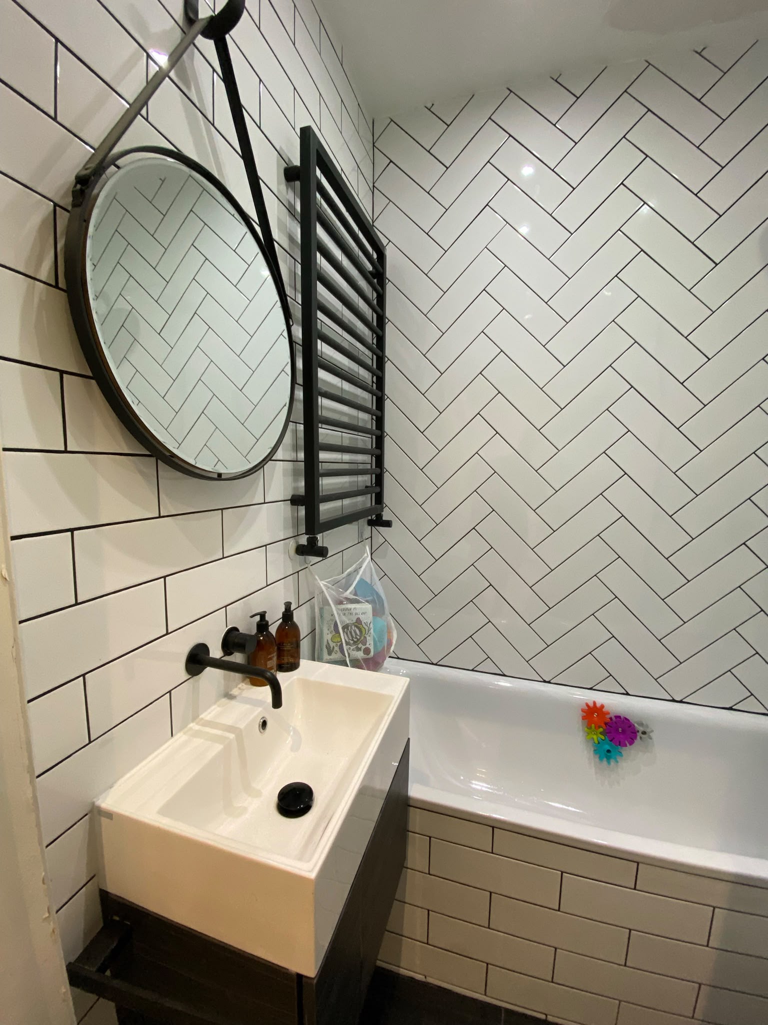 Completed family bathroom with herringbone wall tiles