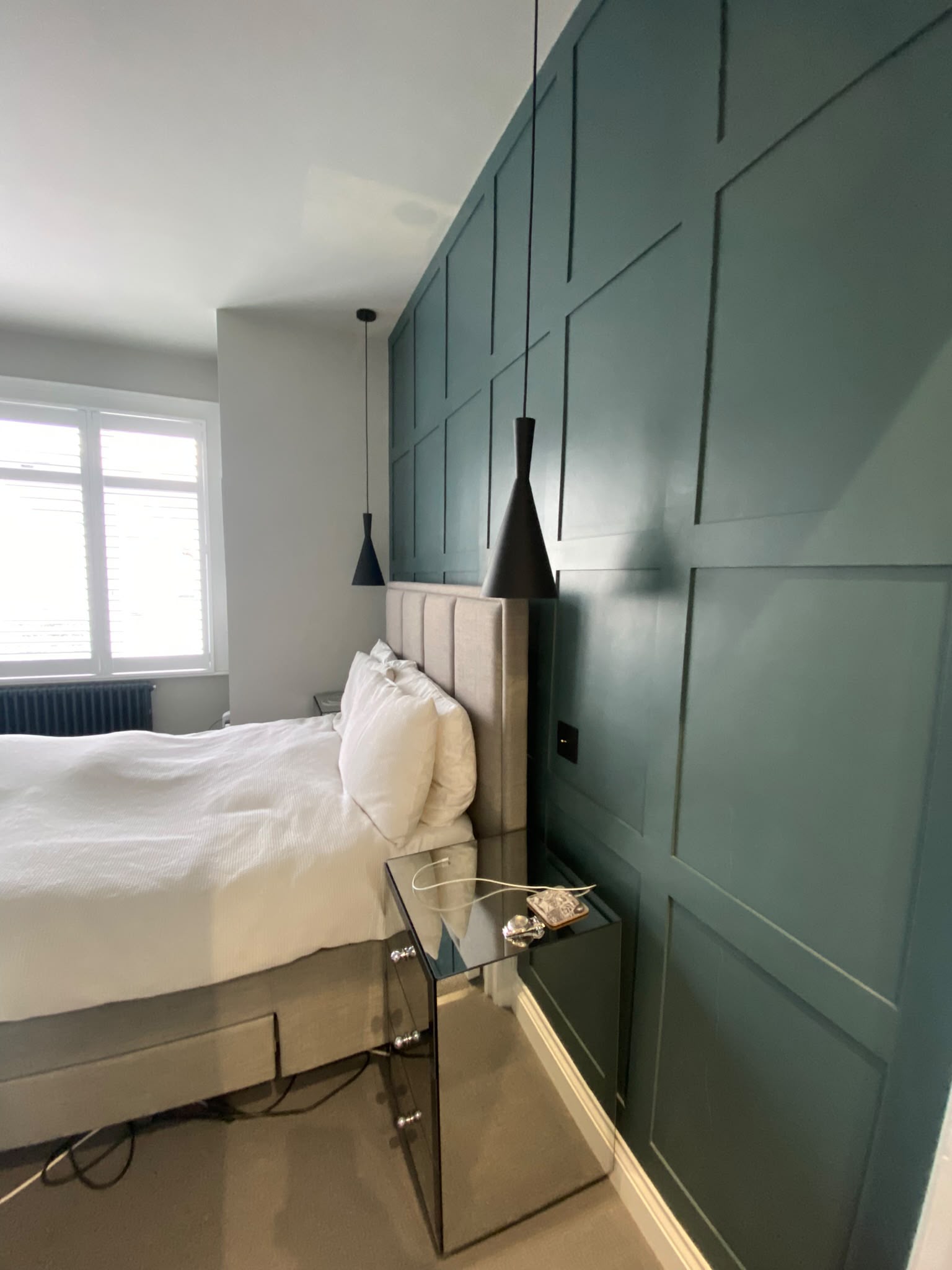 Finished bedroom with blue-green wall panelling