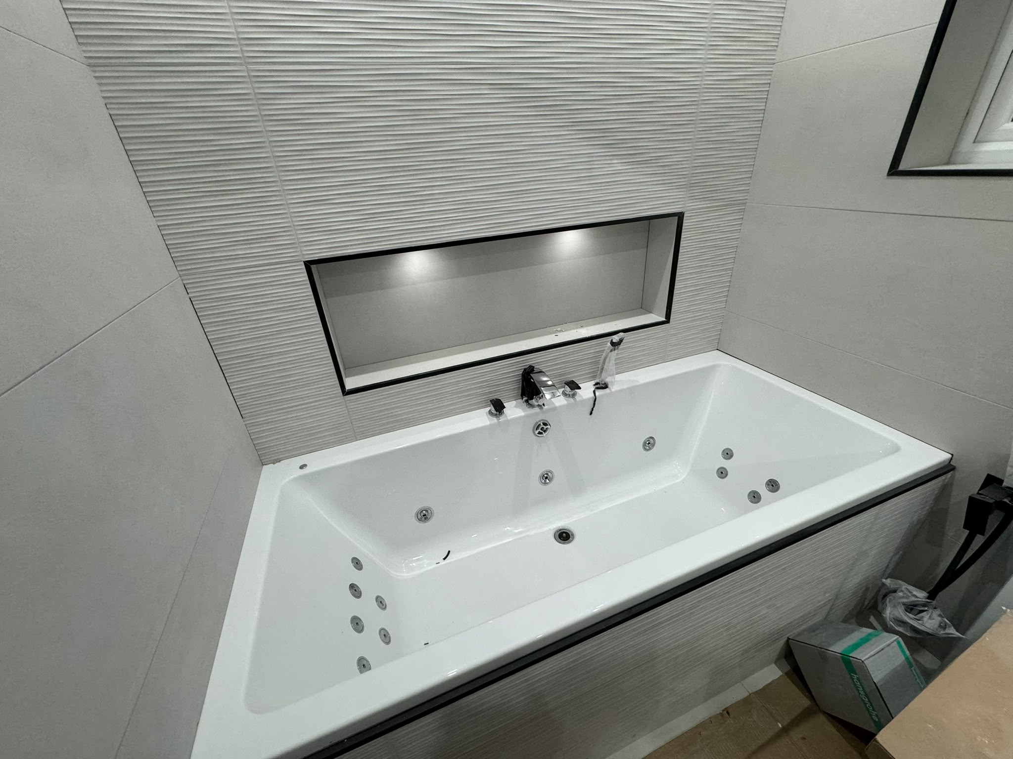 New family bathroom with tiled bath surround